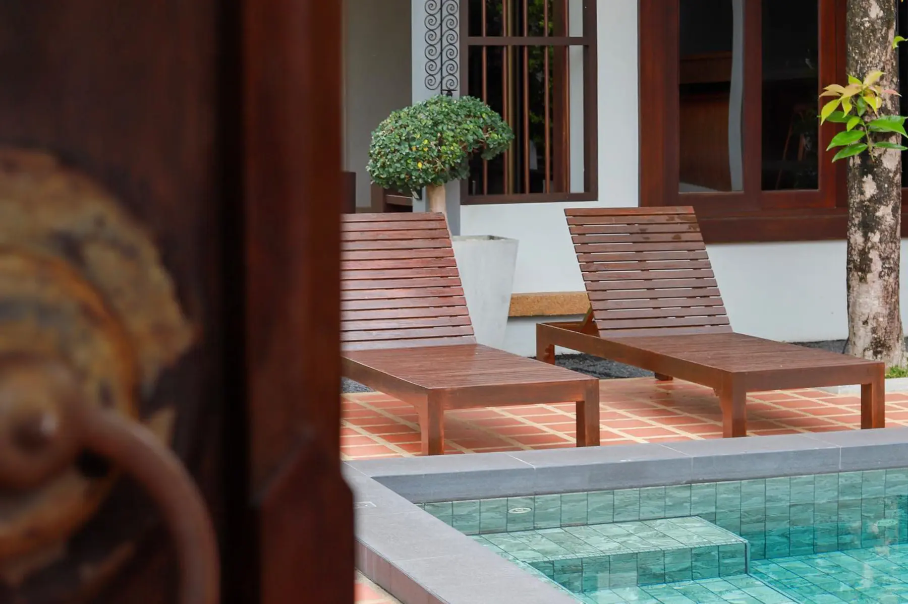 Sunlit poolside loungers at The Nest Samui